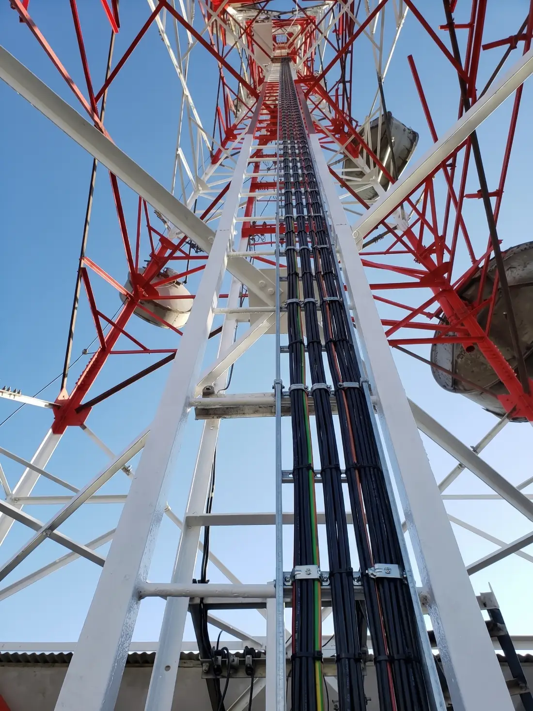 Interior de una torre visto hacia arriba, con un técnico trabajando en altura.
